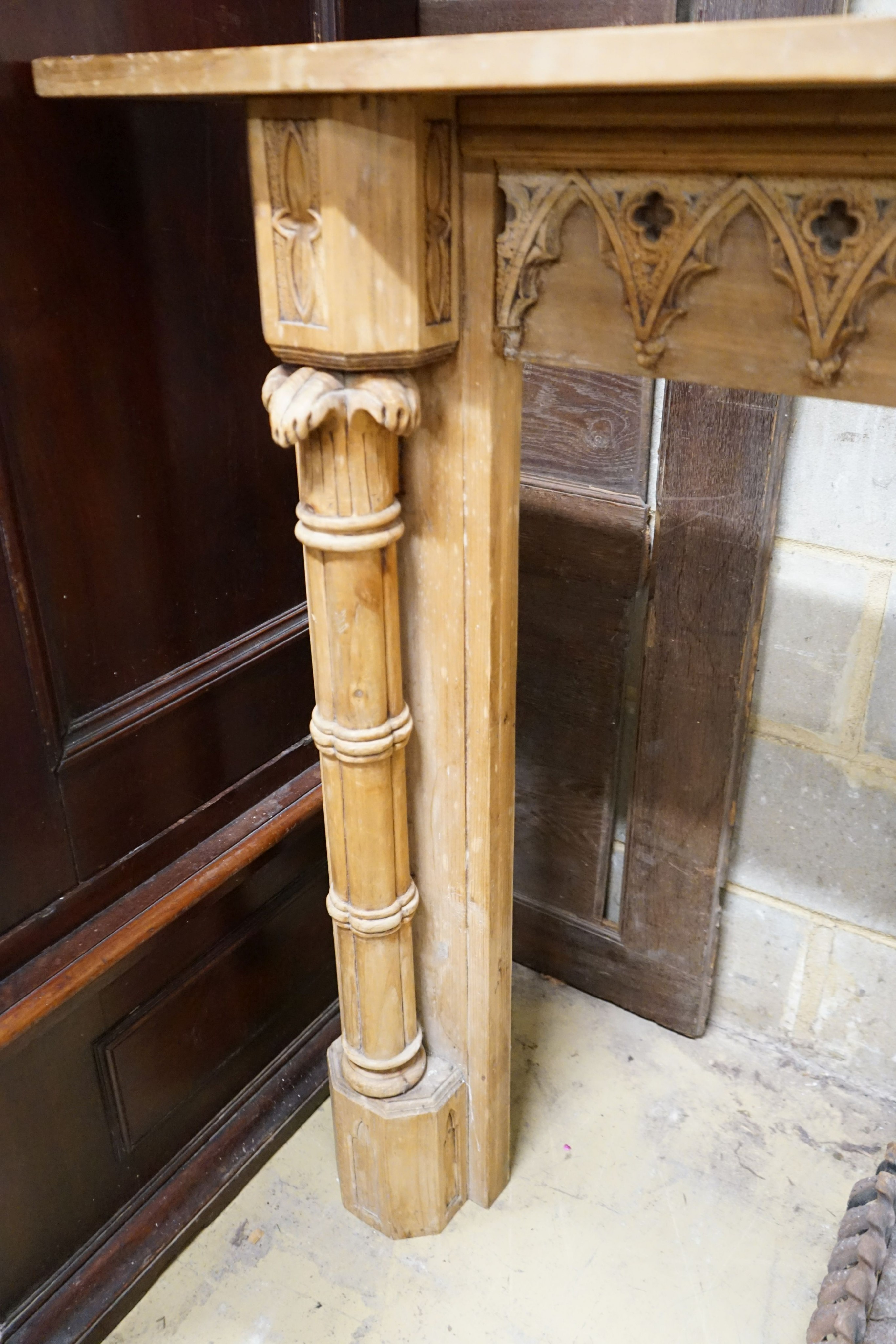 A George III style limewood chimneypiece, in the Strawberry Hill Gothic style, width 150cm, height 111cm together with a cast iron fireback and fire basket (3)